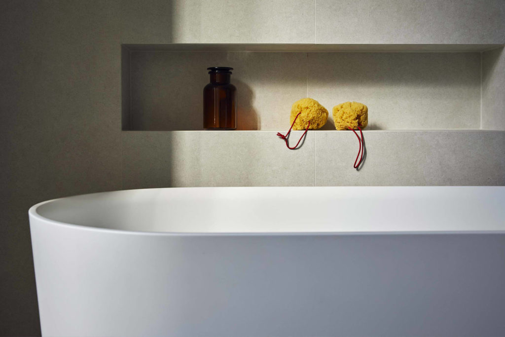 Rénovation d'une salle de bains à Vevey. Carrelage claire avec décrochement dans le mur.