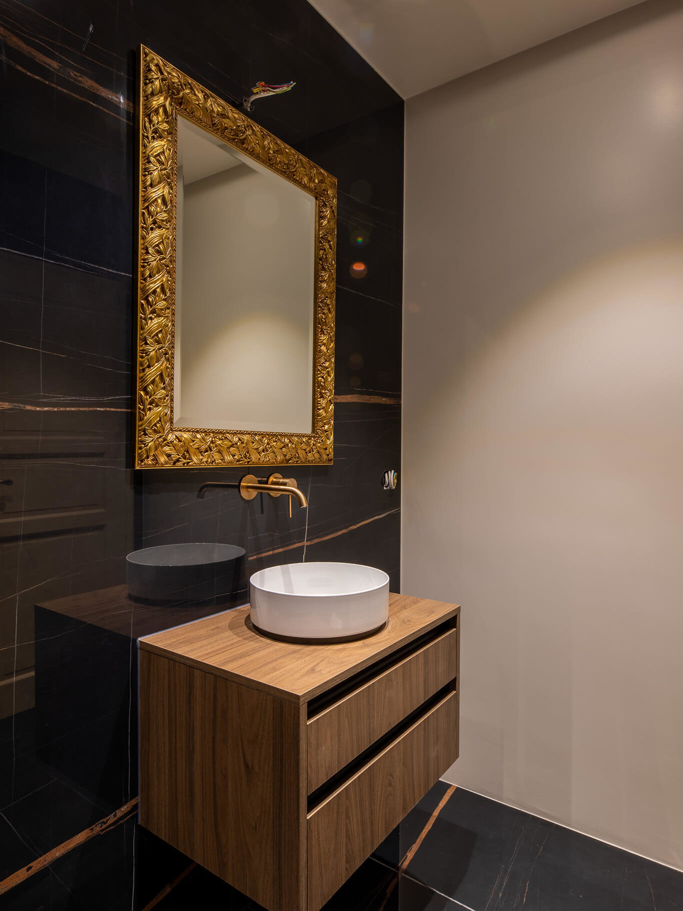Mobilier et installations sanitaires. Carrelage imitation marbre Sahara Black, et miroir doré 