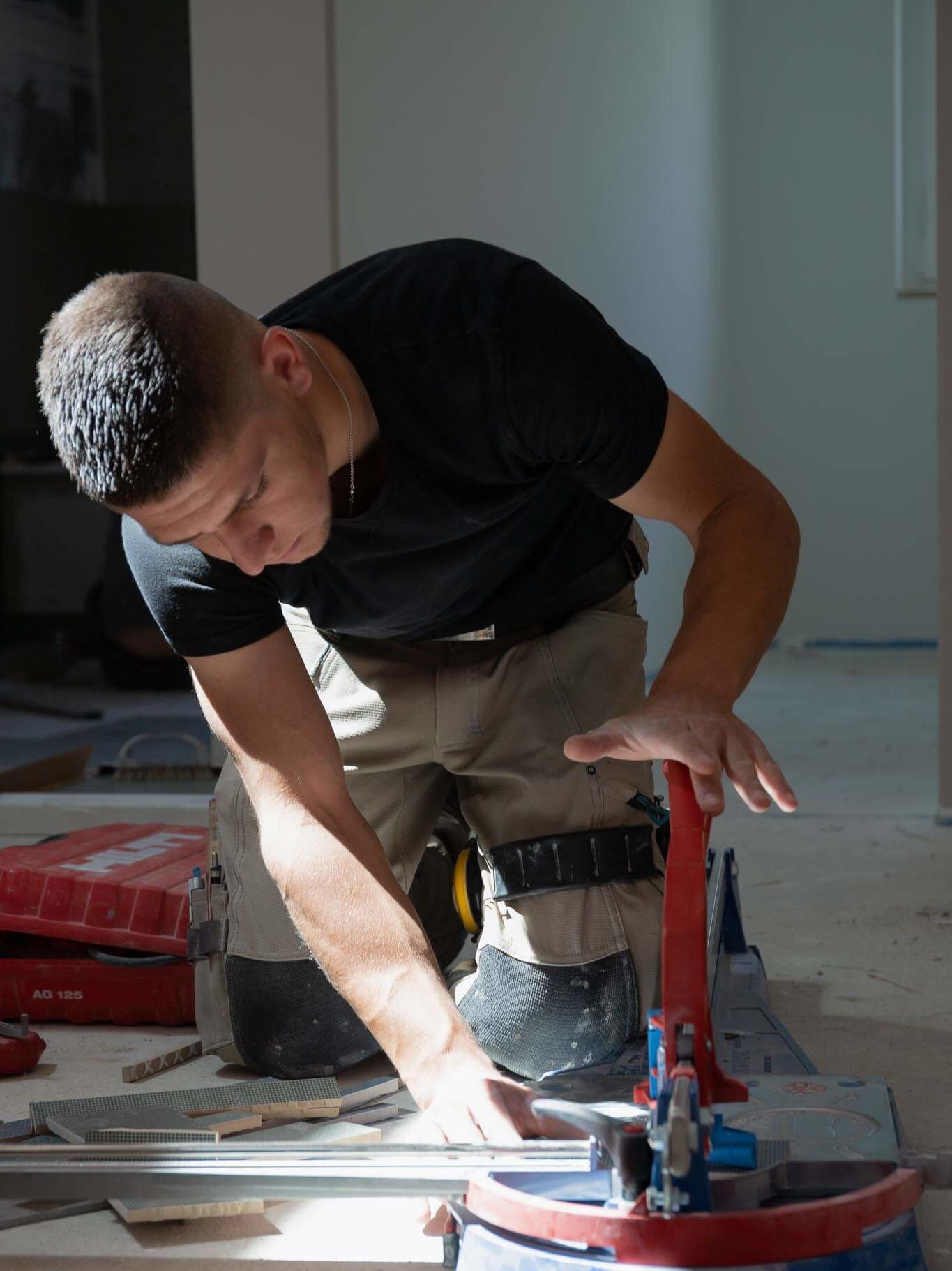 Apprenti qui découpe du carrelage